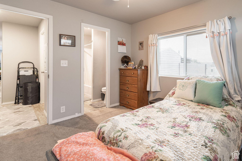 Carpeted bedroom with baseboards and connected bathroom