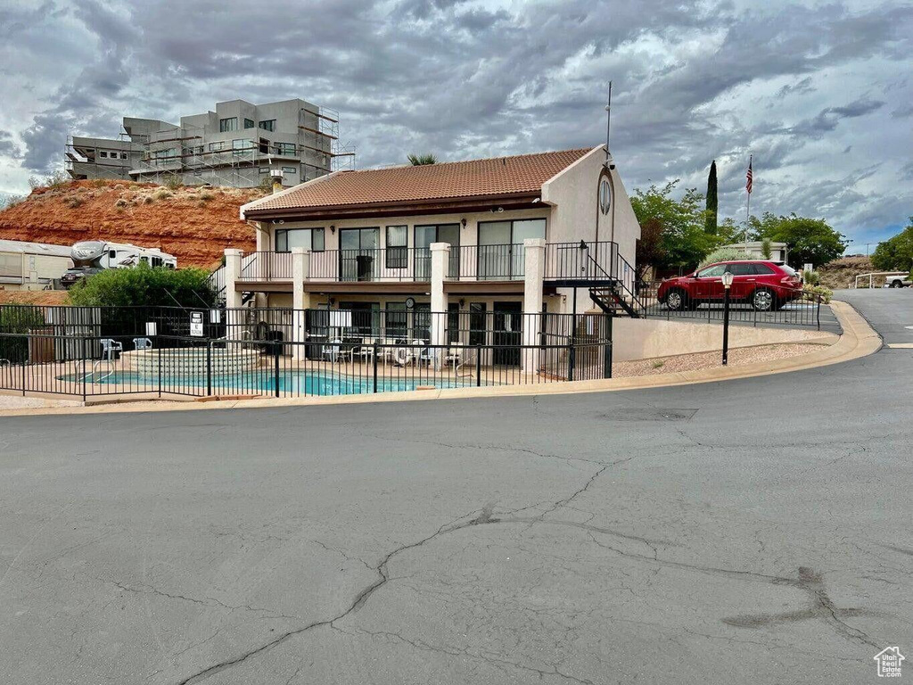 Exterior space featuring a community pool and fence