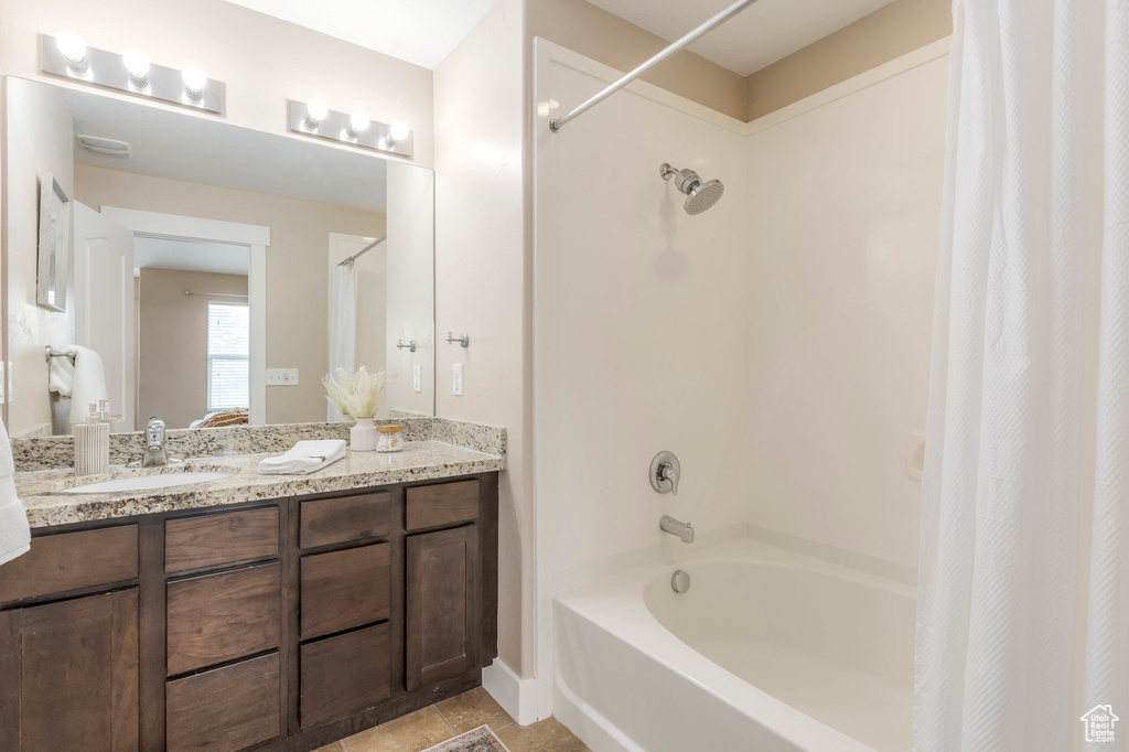 Full bath featuring tile patterned floors, shower / bathtub combination with curtain, and vanity