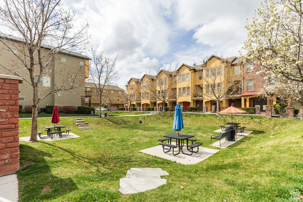 View of property's community featuring a yard and a patio