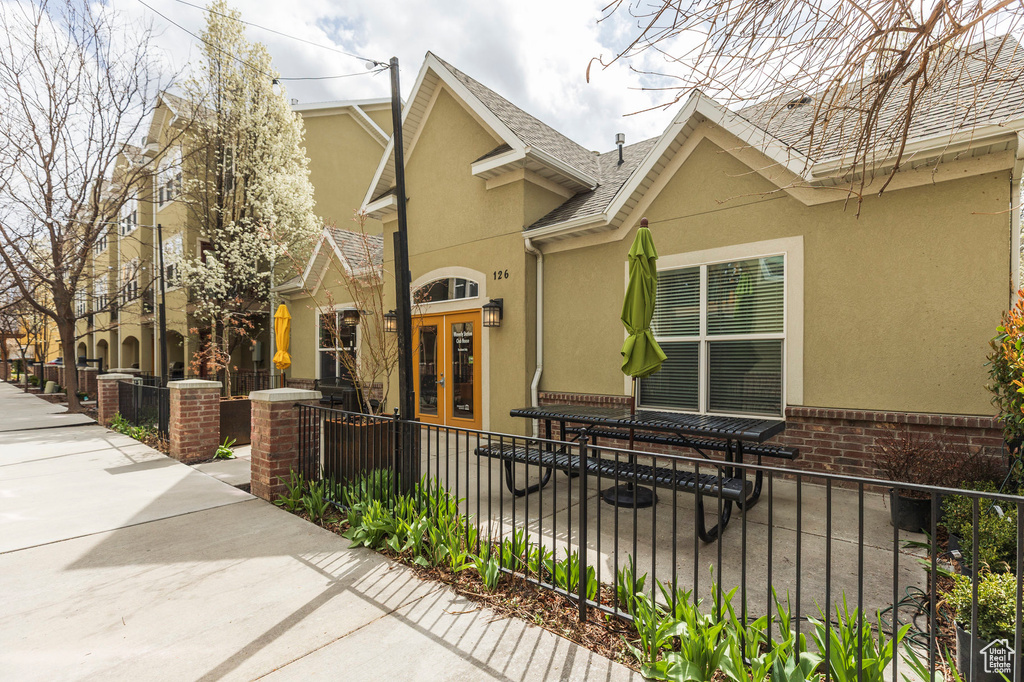 View of home's exterior featuring a fenced front yard, french doors, brick siding, and stucco siding