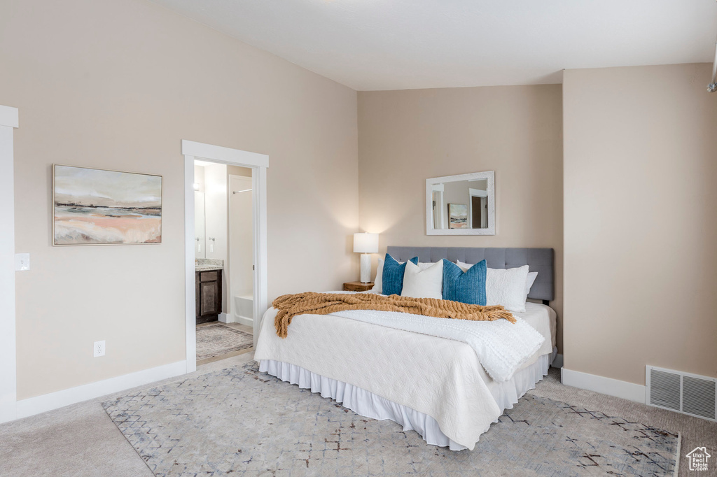 Bedroom featuring ensuite bath, baseboards, visible vents, and carpet floors