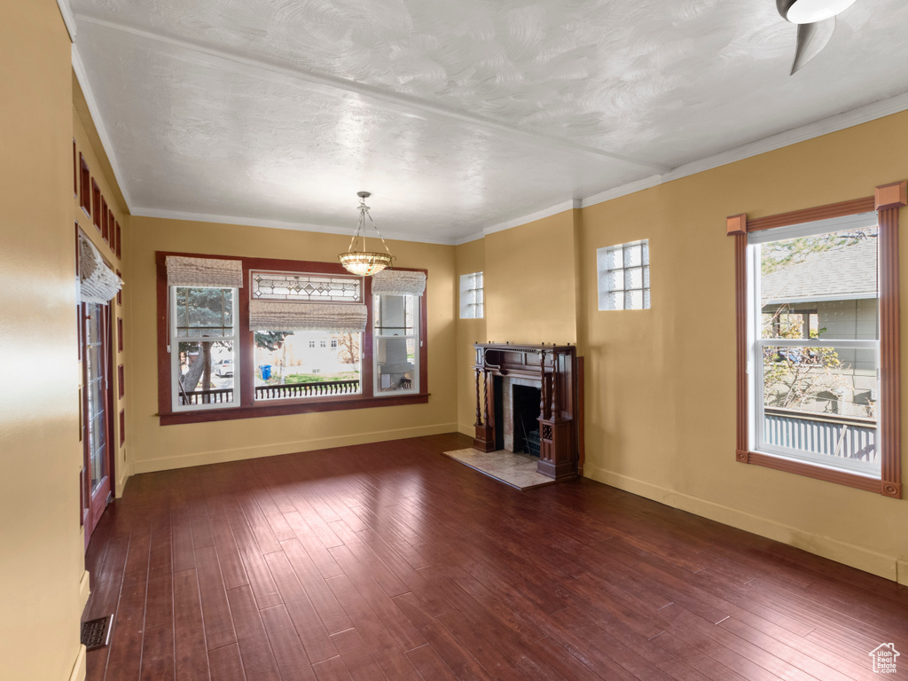 Unfurnished living room featuring a fireplace with flush hearth, hardwood / wood-style flooring, baseboards, and ornamental molding