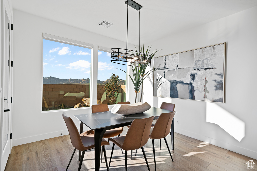 Dining room featuring a chandelier, wood finished floors, a mountain view, and baseboards