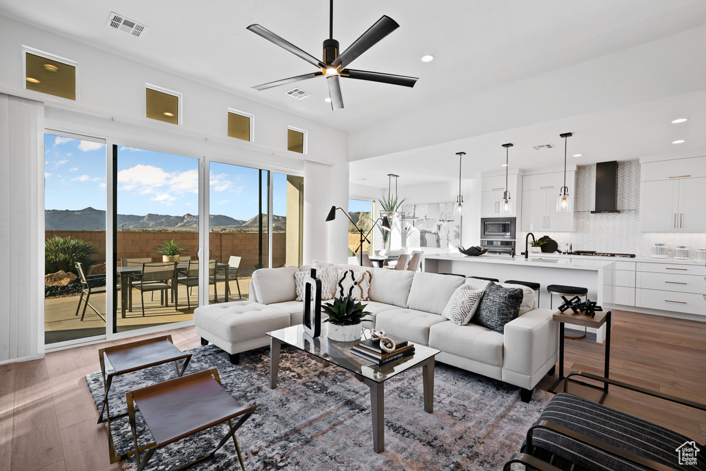 Living area featuring a ceiling fan, recessed lighting, wood finished floors, and a mountain view