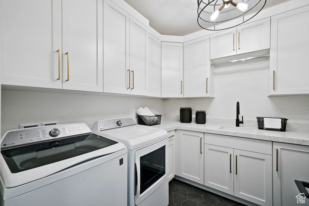 Laundry area with washer and dryer, cabinet space, and dark tile patterned flooring