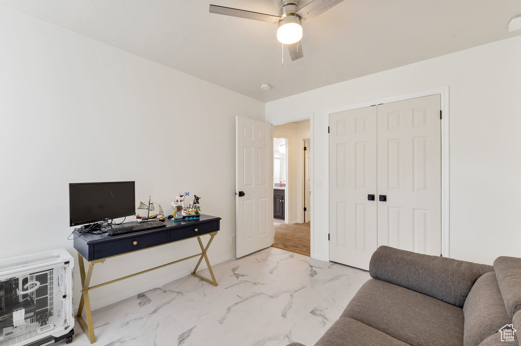 Interior space featuring ceiling fan and marble finish floor
