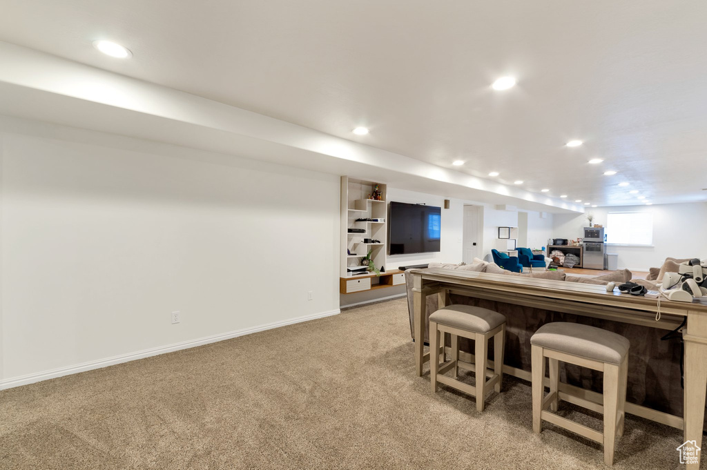 Interior space with a bar, light colored carpet, baseboards, and recessed lighting
