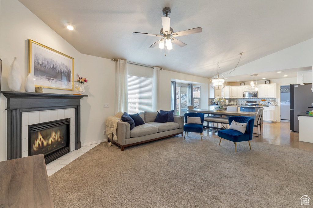 Living area with ceiling fan, light colored carpet, vaulted ceiling, recessed lighting, and a tile fireplace