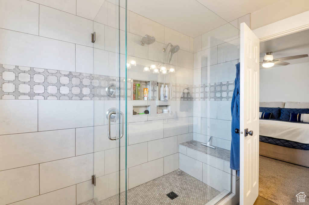 Full bathroom with ceiling fan, a shower stall, and connected bathroom