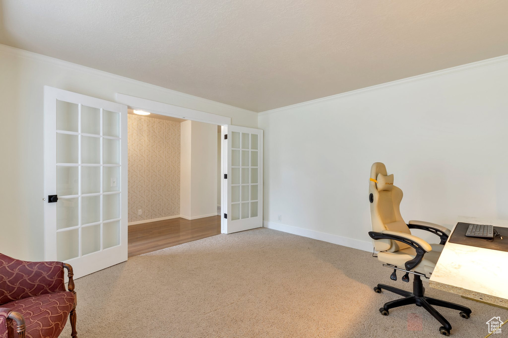 Carpeted office space with french doors, wallpapered walls, baseboards, and ornamental molding