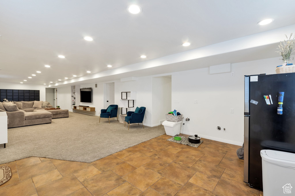 Interior space with freestanding refrigerator, stone finish floor, recessed lighting, carpet flooring, and baseboards