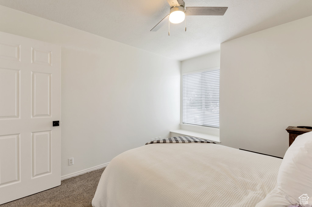 Bedroom featuring carpet floors, baseboards, and a ceiling fan