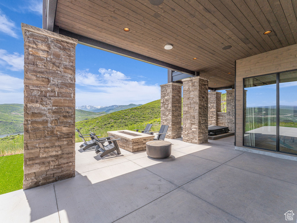 View of patio / terrace with an outdoor fire pit and a mountain view
