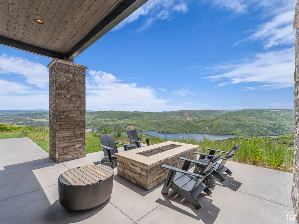 View of patio / terrace featuring a water and mountain view and a fire pit