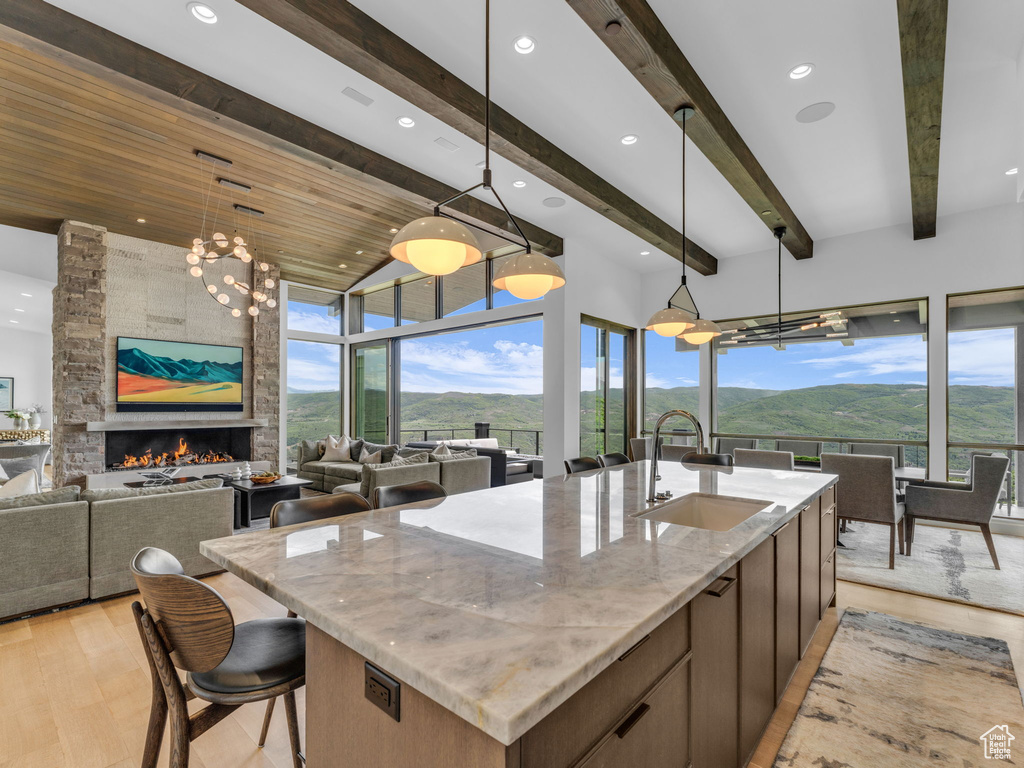 Kitchen with a sink, a mountain view, an island with sink, light stone countertops, and open floor plan