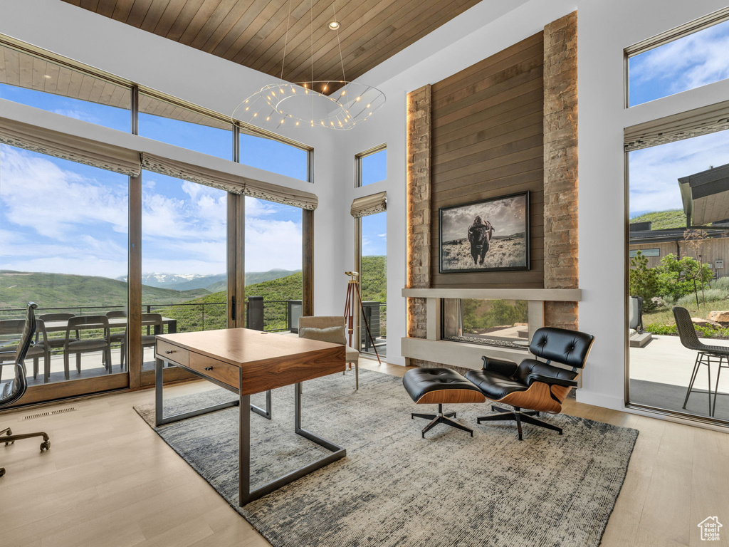Office featuring a mountain view, wood ceiling, wood finished floors, a chandelier, and a towering ceiling