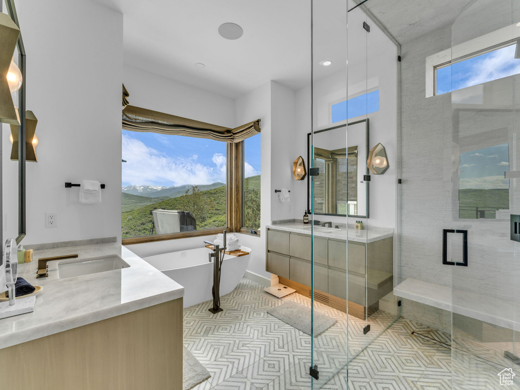 Bathroom featuring vanity, a freestanding tub, a stall shower, a mountain view, and tile patterned flooring