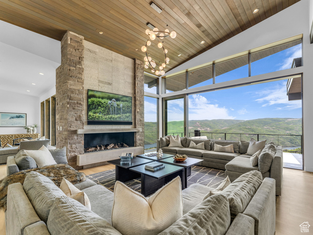 Living area with high vaulted ceiling, wood finished floors, a mountain view, a chandelier, and wood ceiling
