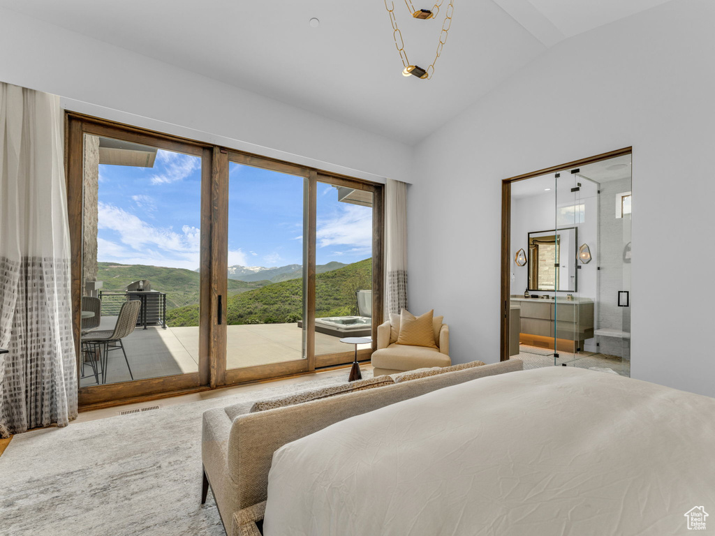 Bedroom featuring access to exterior, lofted ceiling, and a mountain view