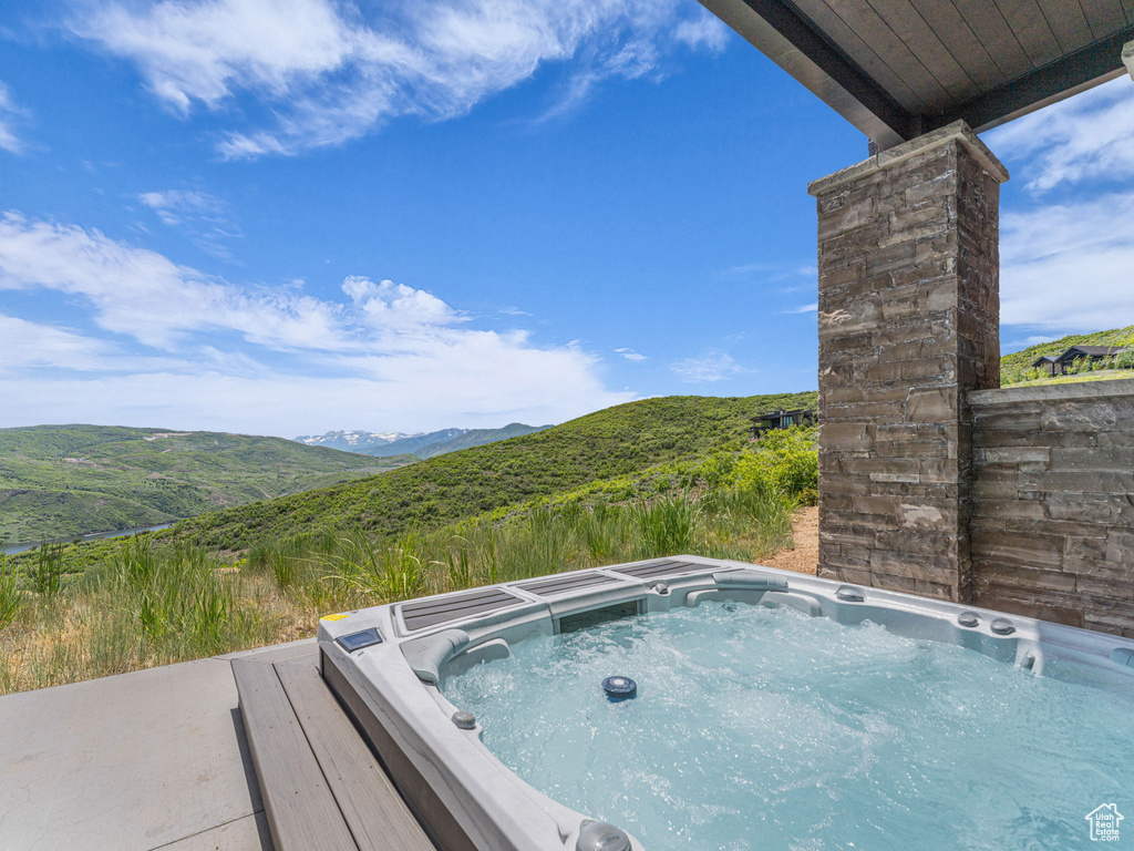 View of swimming pool with a hot tub and a mountain view