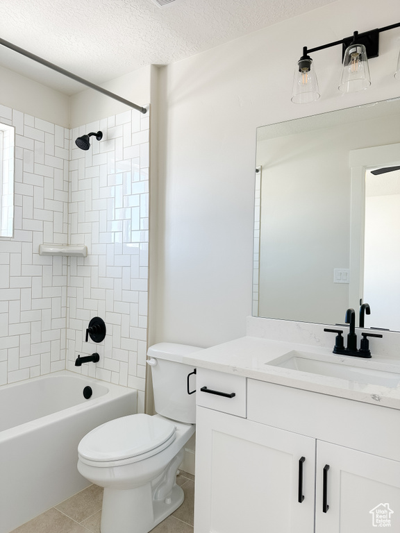 Full bath featuring toilet, tile patterned floors, vanity, tub / shower combination, and a textured ceiling