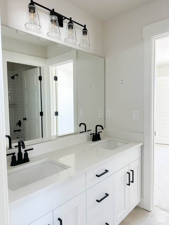 Full bathroom with a tile shower, double vanity, and tile patterned flooring