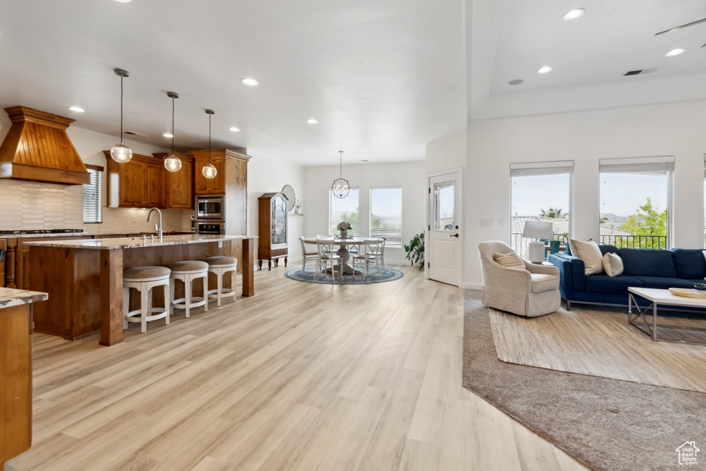 Living room featuring visible vents, light wood-style flooring, recessed lighting, and baseboards