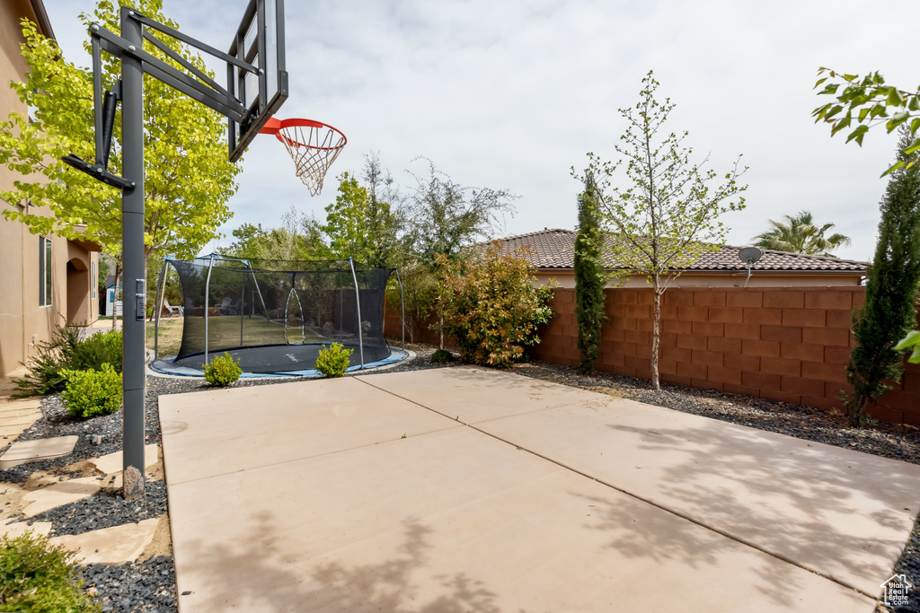 View of basketball court with a trampoline and fence