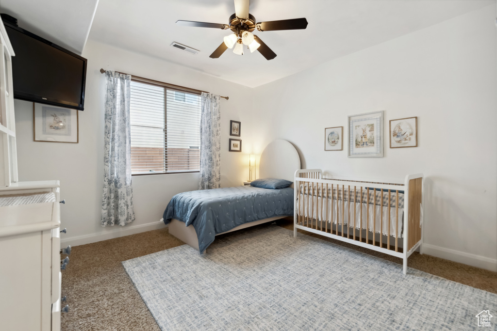 Carpeted bedroom featuring baseboards, a ceiling fan, and visible vents