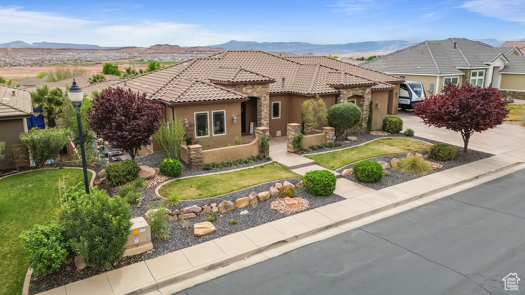 View of front of house with a mountain view, a tile roof, and stucco siding