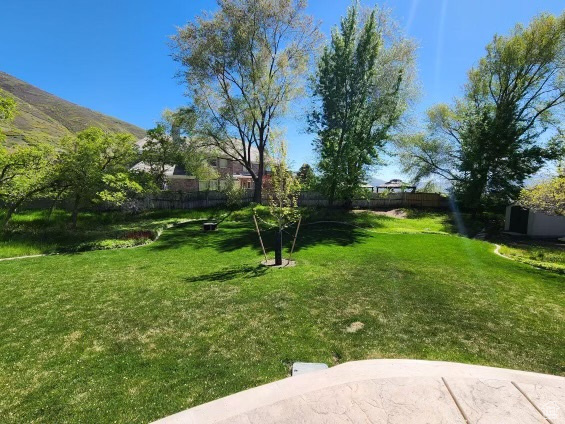 View of yard featuring fence and a mountain view