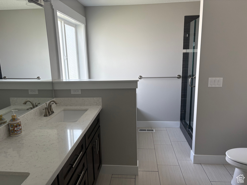 Full bath featuring double vanity and a stall shower