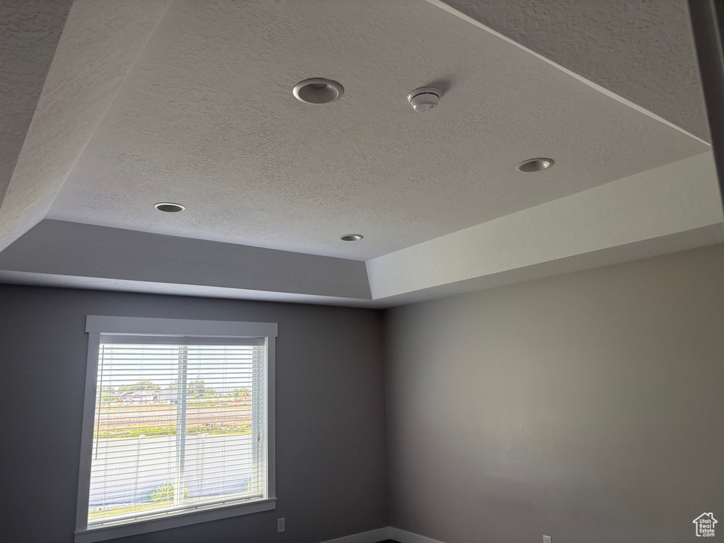 Detailed view of a textured ceiling, recessed lighting, and a smoke detector