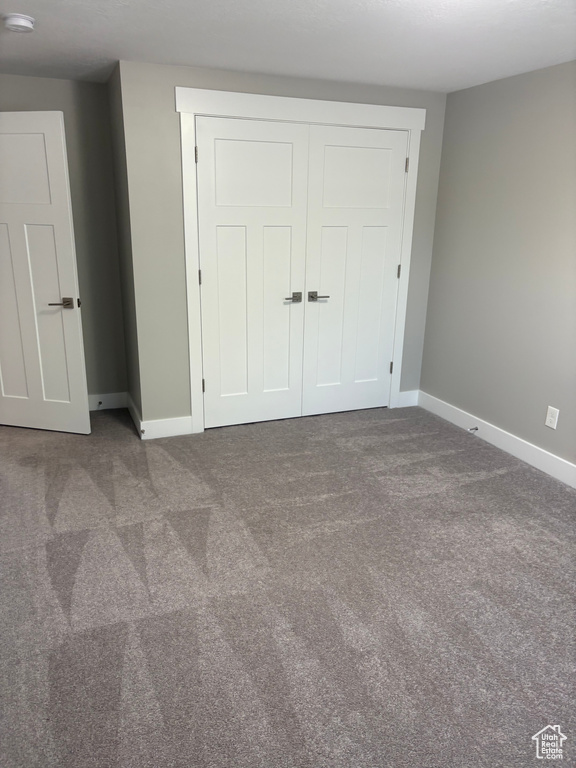 Unfurnished bedroom with carpet flooring and a closet