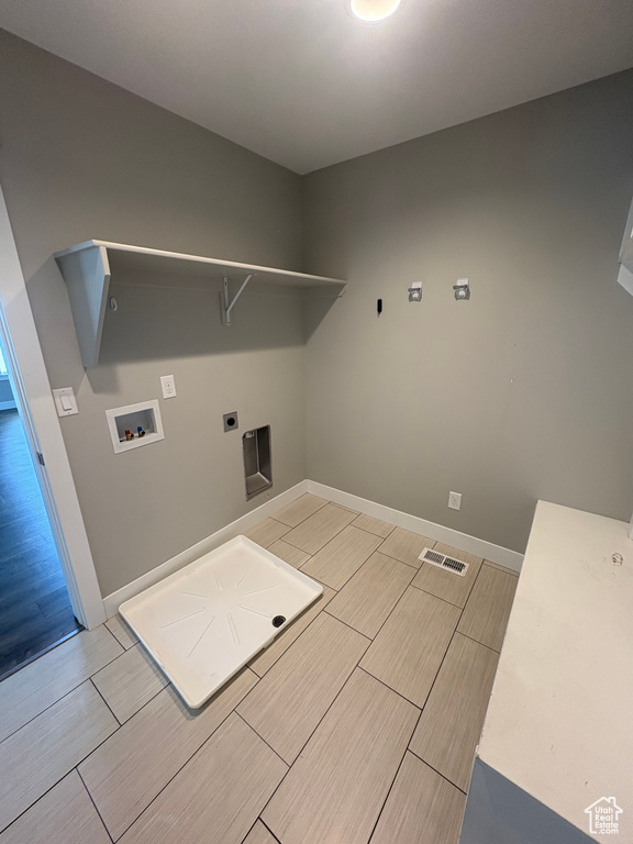 Laundry area with washer hookup, wood tiled floors, and hookup for an electric dryer