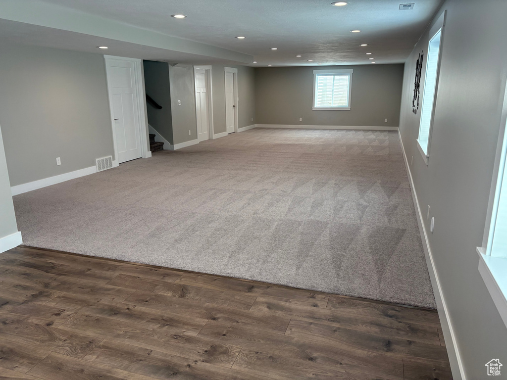 Basement featuring recessed lighting, carpet, stairs, and wood finished floors