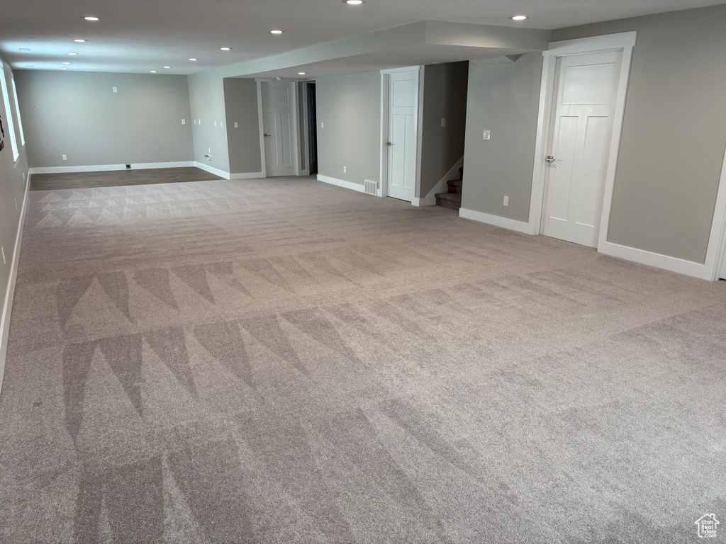Finished basement featuring carpet flooring, recessed lighting, and stairs