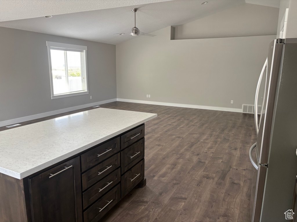 Kitchen featuring freestanding refrigerator, ceiling fan, lofted ceiling, light countertops, and dark wood finished floors