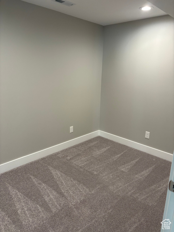 Spare room featuring dark colored carpet and recessed lighting