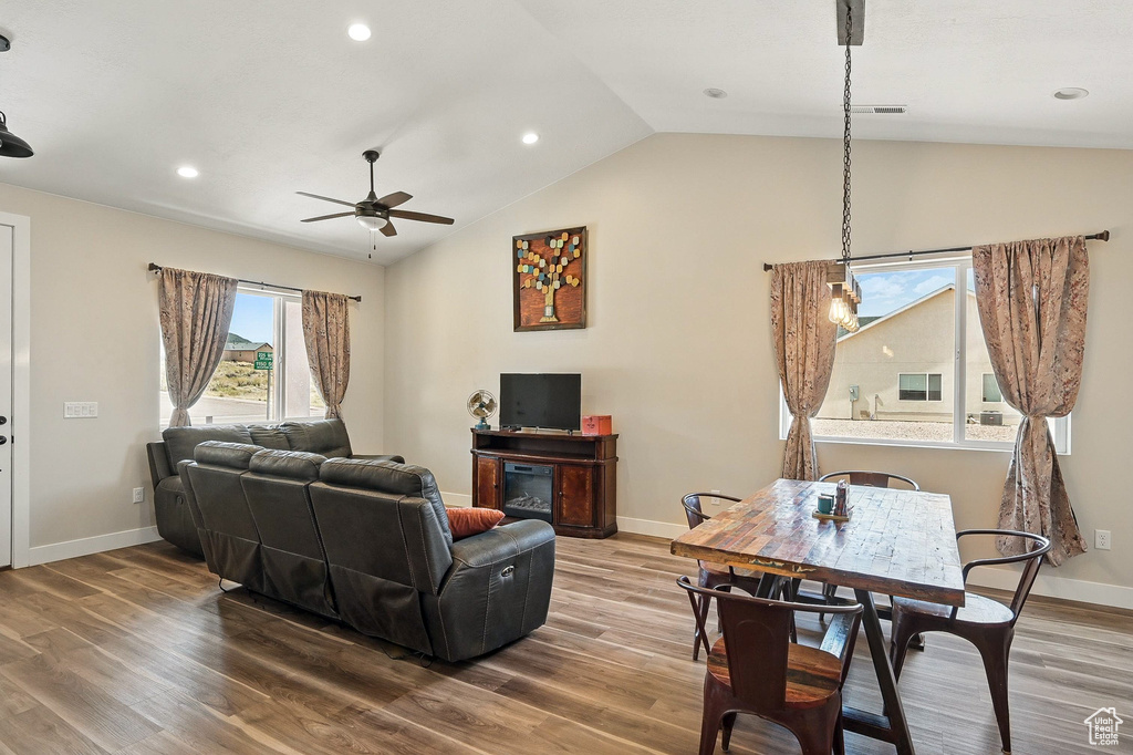 Living area featuring baseboards, visible vents, ceiling fan, lofted ceiling, and wood finished floors