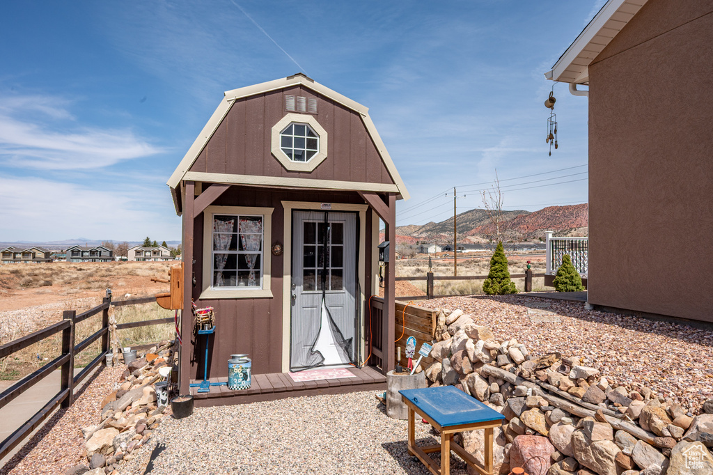 View of shed with a mountain view and fence