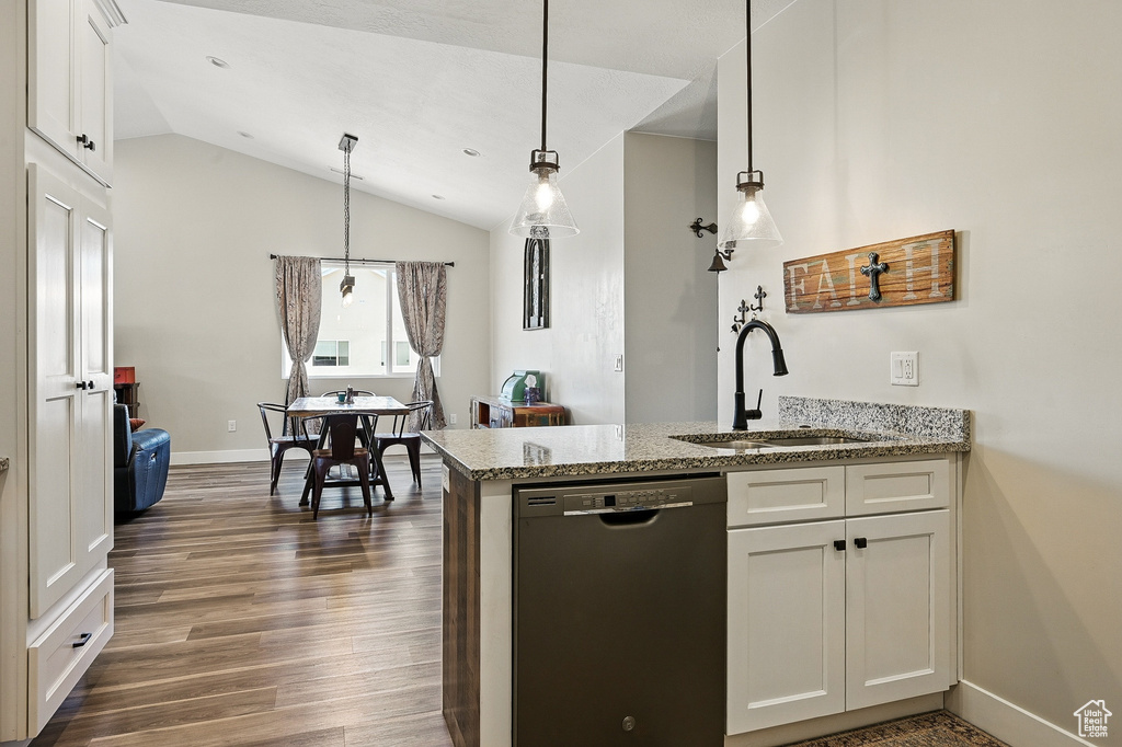 Kitchen with a peninsula, dishwasher, a sink, dark wood-style flooring, and lofted ceiling