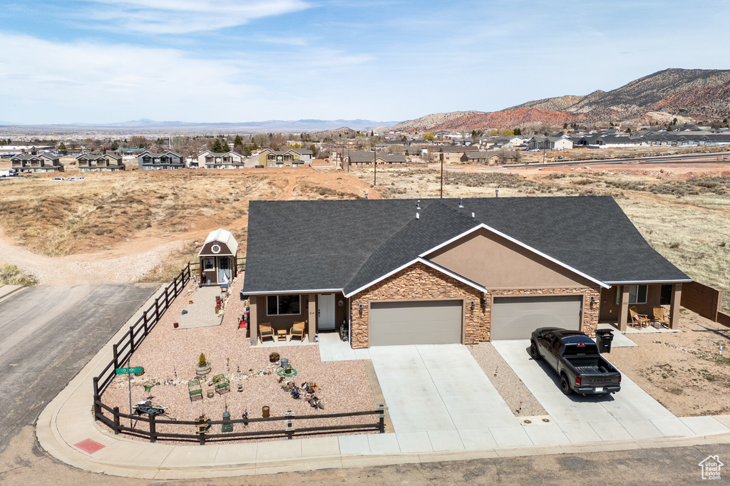 Ranch-style home with a mountain view, a garage, fence, and concrete driveway
