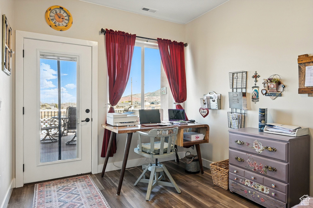 Office space with visible vents, baseboards, and wood finished floors