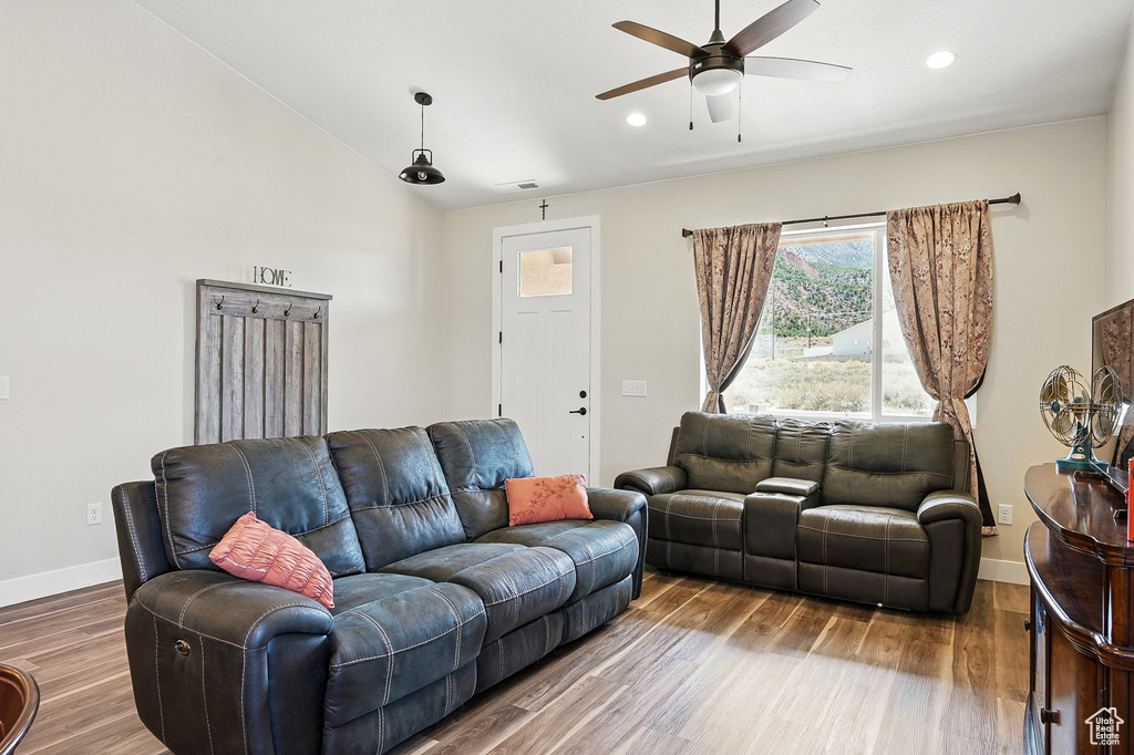 Living area featuring baseboards, visible vents, ceiling fan, lofted ceiling, and wood finished floors