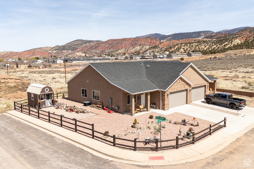 View of front of property featuring a mountain view, an attached garage, and a fenced front yard