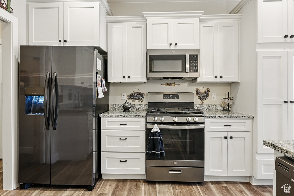 Kitchen with white cabinetry and appliances with stainless steel finishes