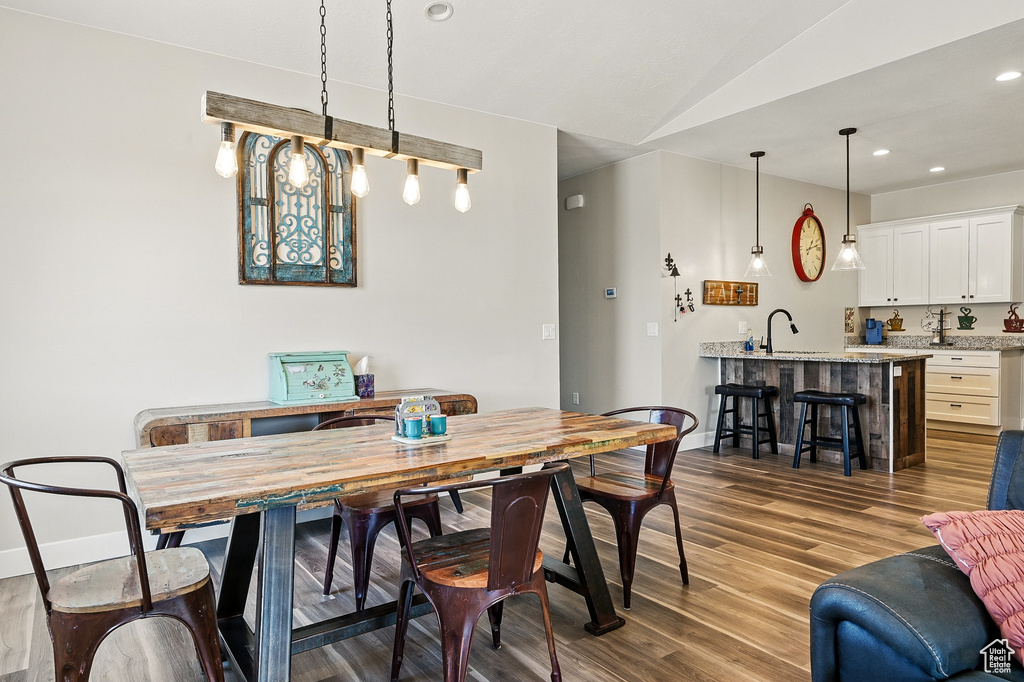 Dining space with baseboards, recessed lighting, lofted ceiling, and dark wood finished floors