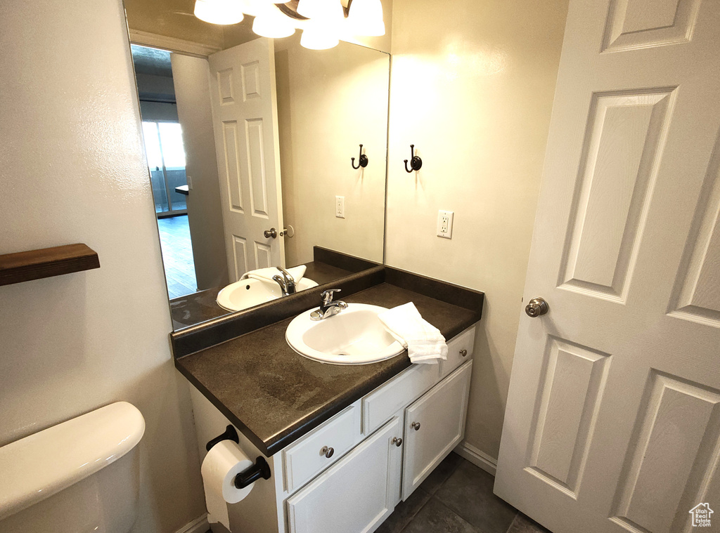 Bathroom featuring vanity, toilet, and tile patterned flooring